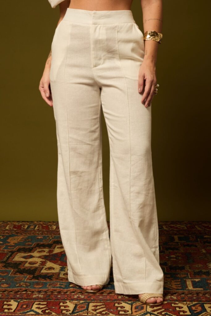 Calça de linho branca wide-leg cintura alta em modelo com acessórios dourados – Branca Boutique