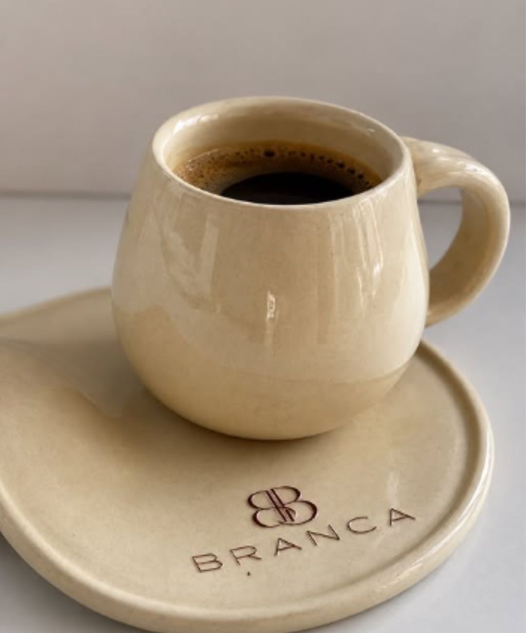 Xícara de café com logotipo Branca Boutique no evento Coffee Itaipava